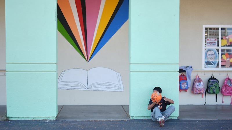 Un estudiante descansa de jugar fútbol durante el recreo en la escuela Perkins --la cual cubre...
