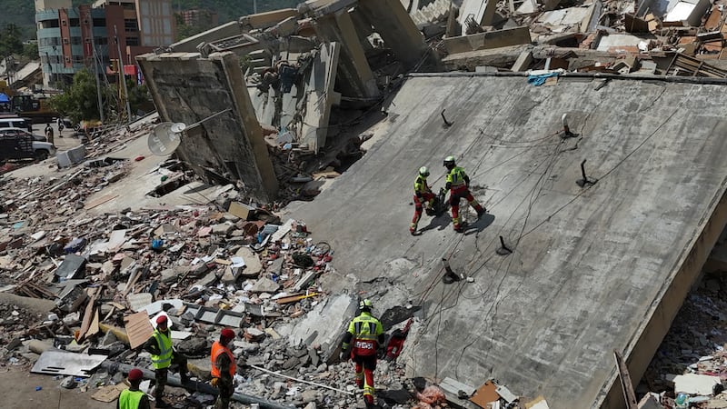 Equipos de rescate del Ejército mexicano buscan a personas atrapadas en edificios derrumbados...