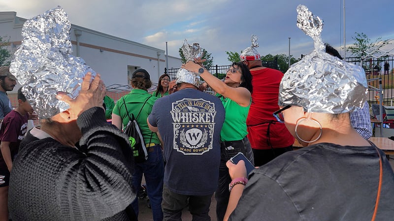 ARCHIVO - Asistentes juegan con sombreros de papel de plata en el Edinburg UFO Festival, el 5...