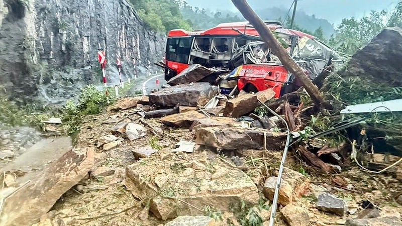 Un autobús de pasajeros yace aplastado por un deslizamiento de tierra el lunes 17 de noviembre...