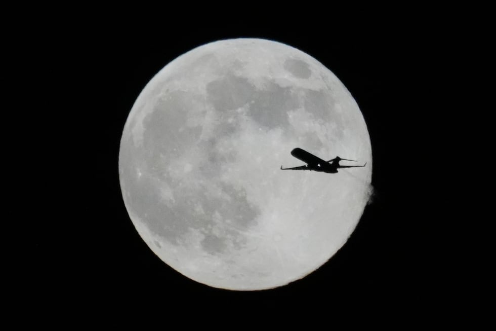 Un avión vuela frente a una Superluna, el jueves 4 de diciembre de 2025 en Chicago. (AP...