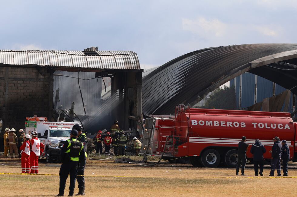 Bomberos y trabajadores de la Cruz Roja acuden al lugar del accidente aéreo cerca del...