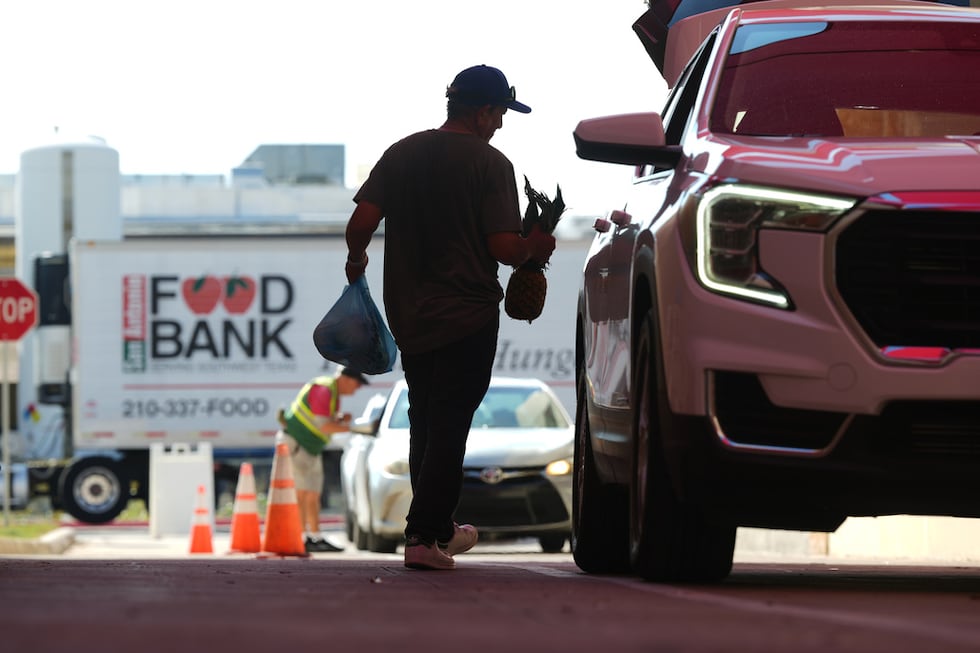 El voluntario Joel Hernandez ayuda a cargar un vehículo durante una actividad de distribución...